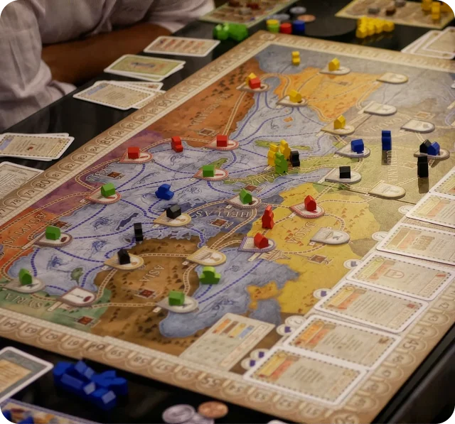 Een close-up van een lopend strategisch bordspel met een gedetailleerde kaart, kleurrijke speelstukken en spelerskaarten. De scène vangt doordachte besluitvorming en de boeiende spelervaring van tafelstrategiespellen.